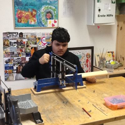 Mostafa sägt eine Holzleiste.